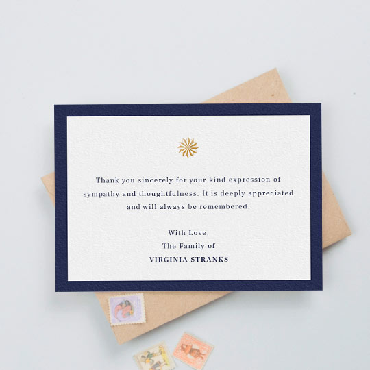 Funeral Thank You Card - "Golden sundial" A funeral thank you card with a thick, navy blue border and an orange/gold sundial icon in the middle. The card has a personalised message of thanks in the middle