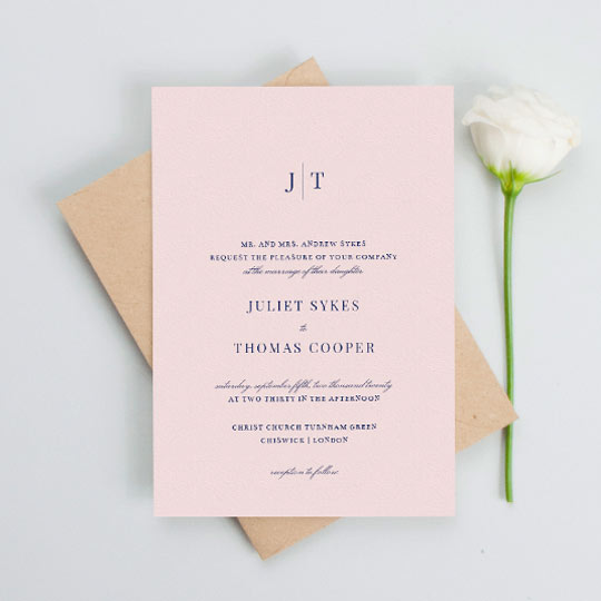 Wedding Invitation (Classic) - "Tradition in Pink" A classic pink wedding invitation with navy blue text. The top of the wedding invitation has a monogram of the bride and groom’s names.