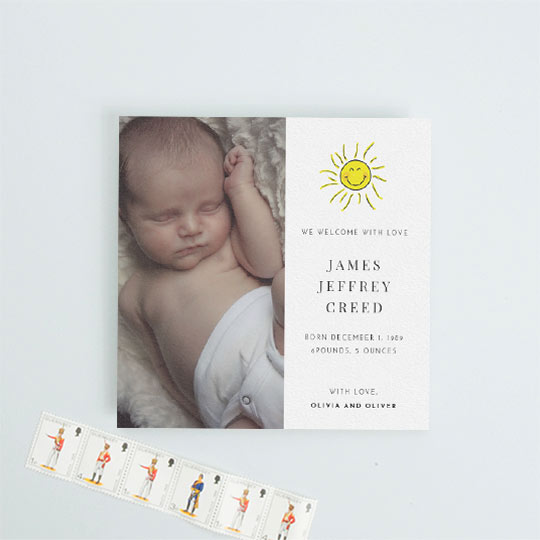 Baby Birth Announcement Card - "Bright Sun" A square baby birth announcement card with a baby photo on the left-hand side. It has a hand drawn picture of the sun smiling on the right-hand side. The baby’s birth details are printed underneath the sun.
