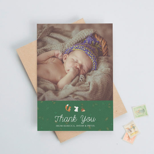 Baby Thank You Card - "Woodland Chums" A baby thank you card with a baby photo at the top with a green, leaf-patterned section below. There are woodland animals above the words "thank you".